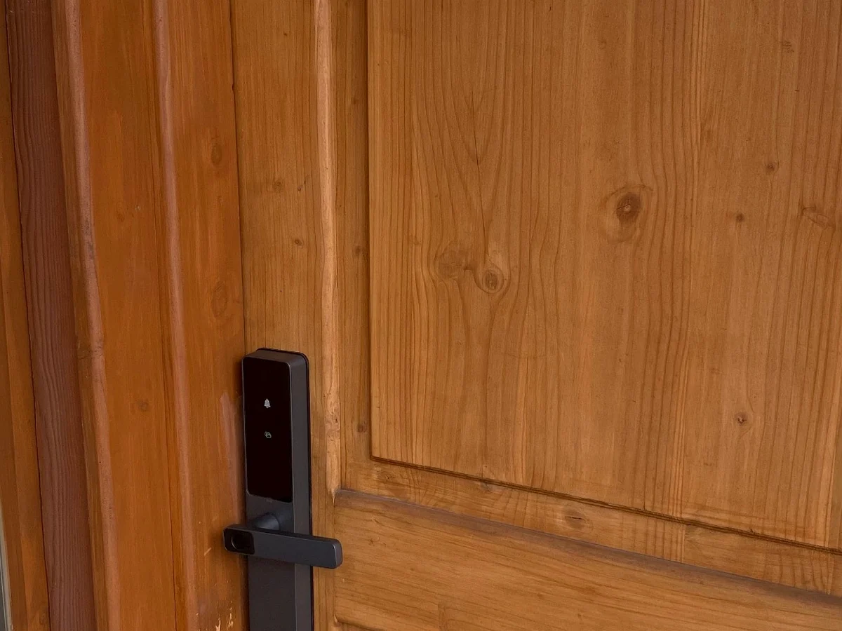 Cerradura inteligente instalada en puerta principal de madera