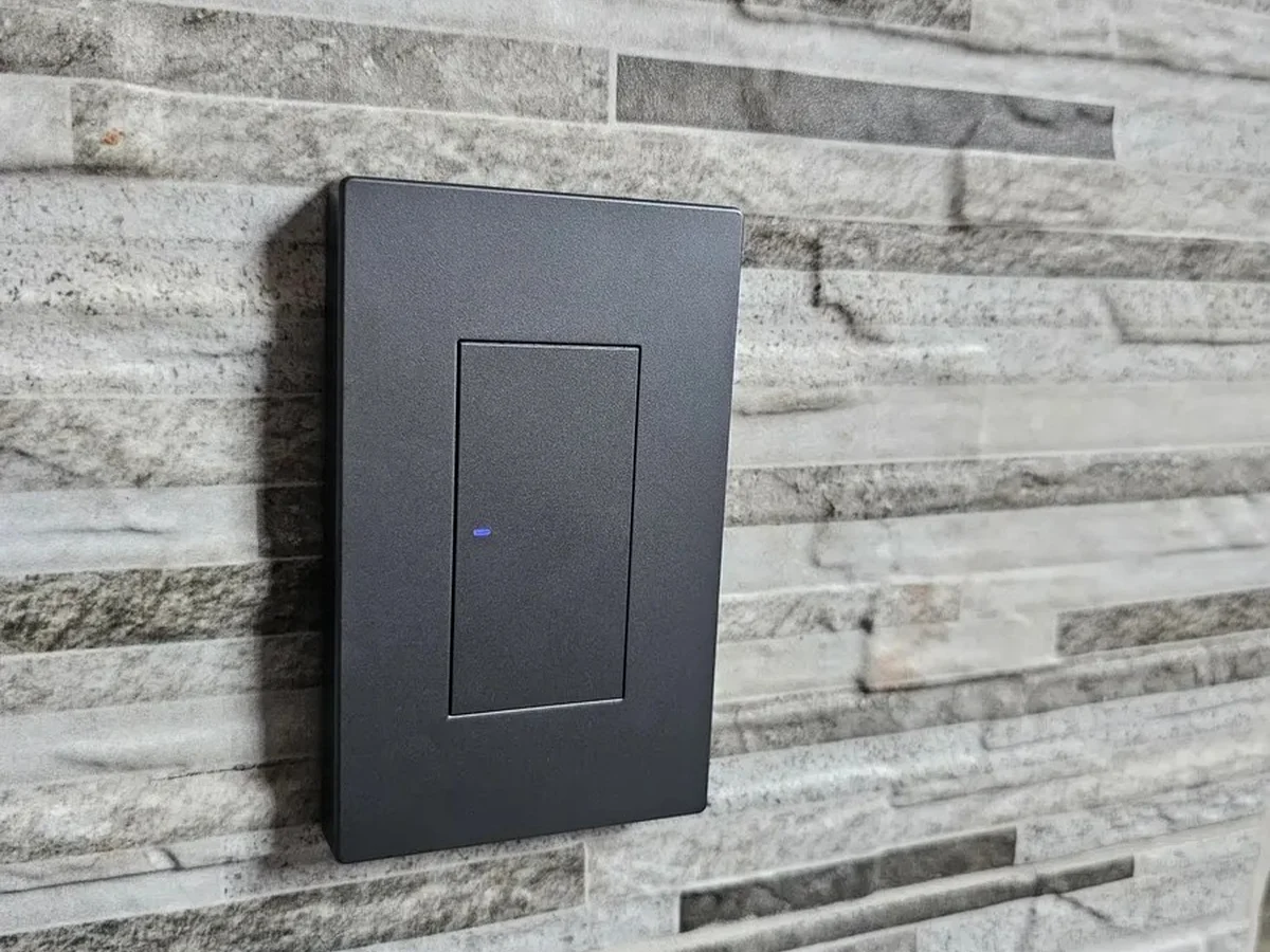 Interruptor inteligente Sonoff M5 instalado sobre muro de piedra